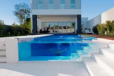 an empty swimming pool with steps leading up to it and a building in the background