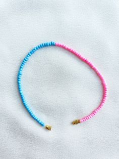 Handcrafted pink and blue beaded anklet/bracelet. Made using small colourful round glass beads and finished with a gold-plated barrel clasp closure. Pair it with our matching Necklace.  * Weight: 3g   * Width: 5mm/2mm  * Made in UK  * Code: 5050APBS The very best in unique, handmade pieces from BAM-BAM, our anklets and bracelets make great accessories for the beach, festival or club. These small beads have a dainty appearance and can take your best looks from day to night. Pink Beaded Anklets For Summer, Pink Beaded Summer Anklets, Adjustable Pink Anklet With Colorful Beads, Summer Pink Anklet With Colorful Beads, Pink Heishi Beads Vacation Bracelets, Pink Heishi Beads Bracelets For Vacation, Blue Heart Beads Bracelets For Beach, Blue Beaded Bracelets With Heart Beads For Beach, Blue Heart Beaded Bracelets For Beach