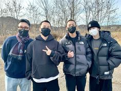 three men wearing face masks standing next to each other