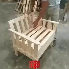 a man pushing a cart made out of wooden pallets with wheels on the floor