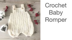 the crochet baby romper is laying next to some red berries