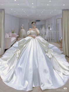 a woman in a white wedding dress is posing for the camera