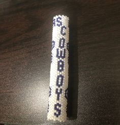 a beaded toothbrush sitting on top of a wooden table