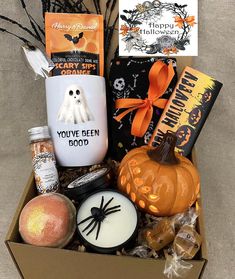 a halloween gift box filled with treats and candles