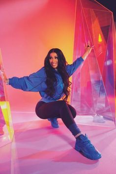 a woman is posing for a photo in front of some plastic structures and neon lights