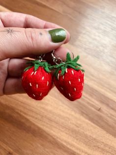 someone is holding two tiny strawberries in their hand