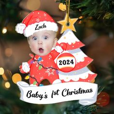 a baby's first christmas ornament hanging from a christmas tree