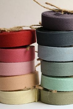 several rolls of ribbon are stacked on top of each other in different colors and sizes