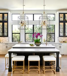 a large kitchen with white cabinets and black counter tops, along with an island in the middle