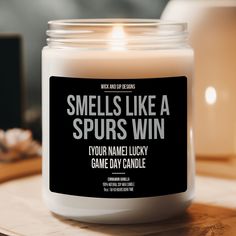 a candle that says smells like a spur's win on the front and side