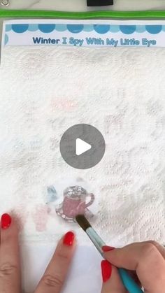 someone is using a brush to paint the paper with white powder on it and writing