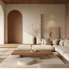 a living room filled with lots of white furniture and wooden accents on top of it