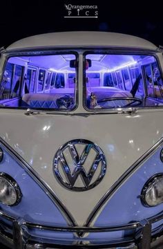 an old vw bus is shown with its lights on and the front door open