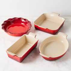 three red and white dishes sitting on top of a marble counter next to each other