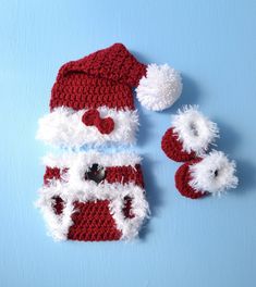 a crocheted santa hat and small stuffed panda bear laying next to it on a blue surface