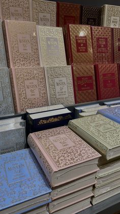 many different colored books are stacked on top of each other in a store display case