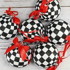 black and white ornaments with red ribbon on them