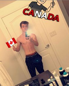 a man is taking a selfie in the mirror with his cell phone and canadian flag