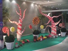 an indoor display with candy canes and trees on the ground in front of a wall