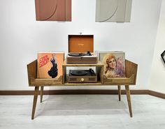 an old record player sitting on top of a wooden table next to other records and cds