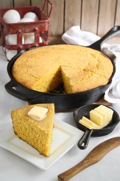 a piece of cornbread cake on a plate next to a skillet with butter