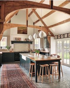 a large kitchen with an island in the middle and lots of stools around it