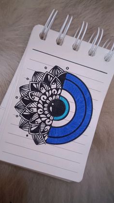 a spiral notebook with an image of a flower on the front and blue circle in the middle