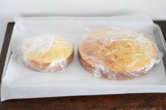 two pastries wrapped in plastic sitting on top of a white plate