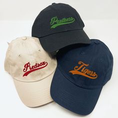 three baseball caps sitting on top of each other in front of a white background,