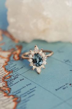 a blue and white diamond ring sitting on top of a map