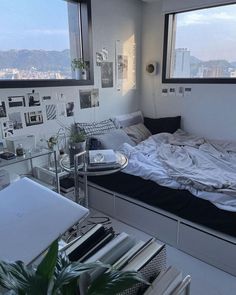 a bed sitting in a bedroom next to a window with lots of pictures on the wall