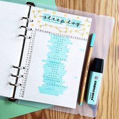 an open notebook with writing on it next to a pen and eraser sitting on top of a wooden table