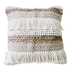 a white and brown pillow with fringes on the front, sitting against a white background