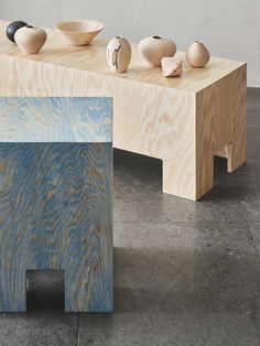 three wooden bowls are sitting on top of a bench with two different colored wood pieces