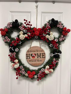 a mickey mouse wreath hanging on a door with the words welcome home in red, white and black