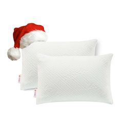 two white pillows with santa hats on them