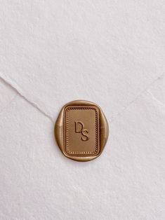 an envelope with a wax stamp on it and the letter s is shown in gold