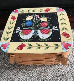 a painted table sitting on top of a carpeted floor next to a fire place