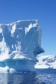 an iceberg floating in the water with snow on it