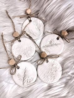 four white ceramic ornaments tied with twine