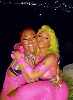 two women in pink outfits hugging each other