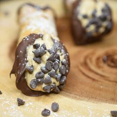 chocolate covered doughnuts are sitting on a cutting board