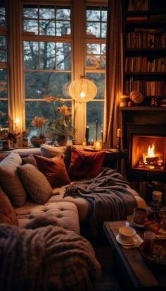 a living room filled with furniture and a fire place in front of a window covered in blankets