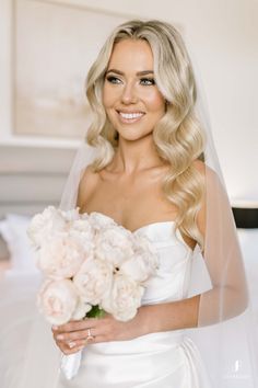 a woman in a wedding dress holding a bouquet of flowers