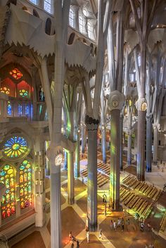 the interior of a large building with stained glass windows and columns on each side of it