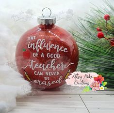 a red ornament that says the influence of a good teacher can never be erased