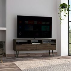 a flat screen tv sitting on top of a wooden entertainment center in a living room