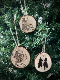 three wood burned ornaments hanging from a christmas tree with the silhouettes of two people holding hands