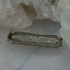 "Antique 14K White Gold Art Deco Diamond Filigree Pin, 1.75\" x .75\", 7 round diamonds F VS quality, all over filigree, locking clasp, larger center stone, Circa 1930, 5.3 grams Stock # BB251BA04 This listing contains photographs of the actual item you will receive. Our items are in excellent condition with little or no signs of wear and many are one of a kind pre-owned estate finds. Please look closely at the pictures in this listing as they are part of the product description. Please read the Art Deco 14k White Gold Hallmarked Jewelry, Art Deco White Gold Brooch, Art Deco Hallmarked White Gold Bracelets, Silver Art Deco Clip-on Jewelry, Silver Art Deco Filigree Brooches, Gold Art Deco, Art Deco Diamond, Fine Jewelry Designers, Gold Art