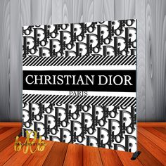 a black and white book with the word christian dior on it, sitting on top of a wooden floor